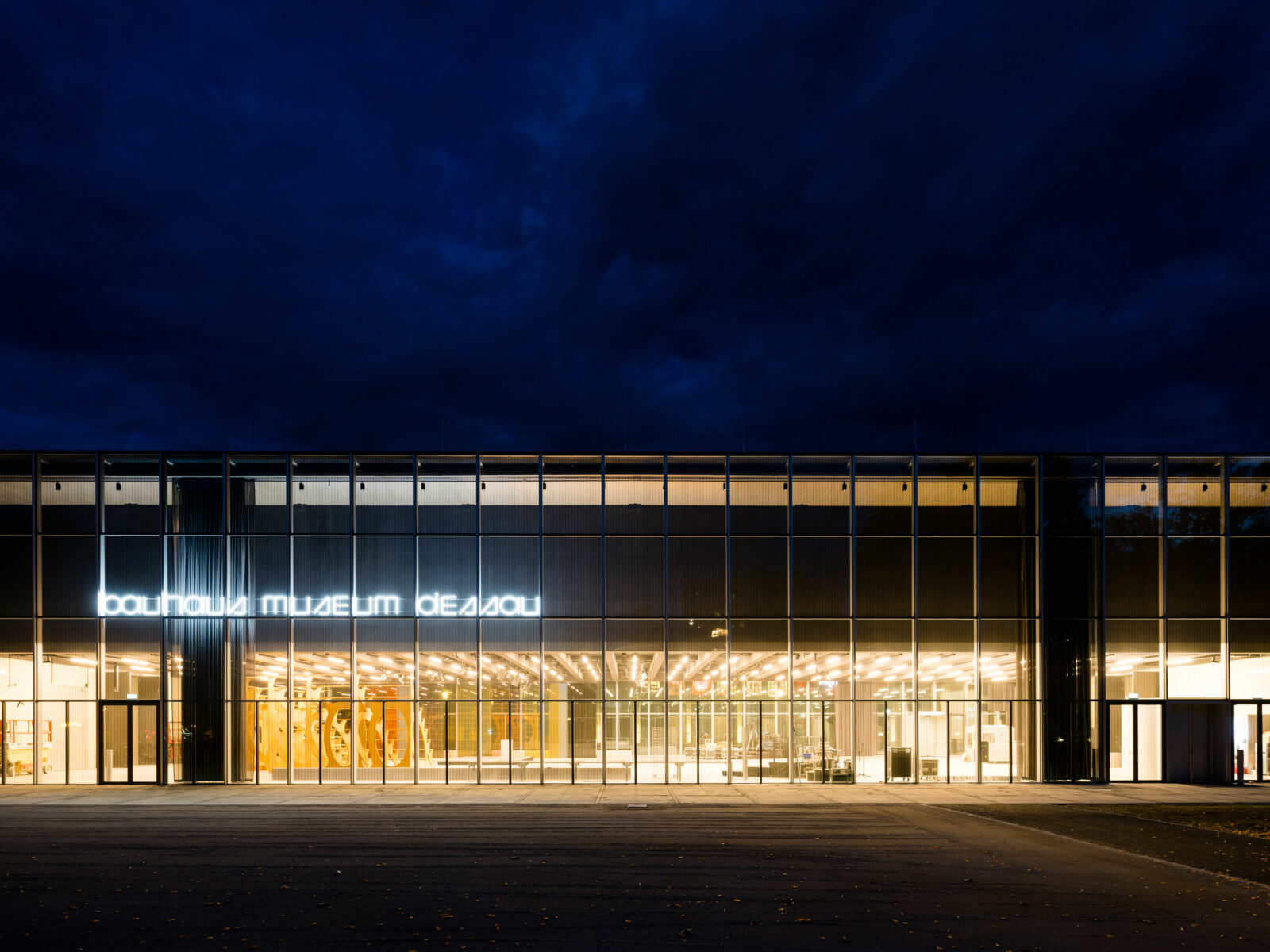 Bauhaus Museum Dessau in der Nacht. Die obere Etage scheint über dem Erdgeschoss zu schweben.