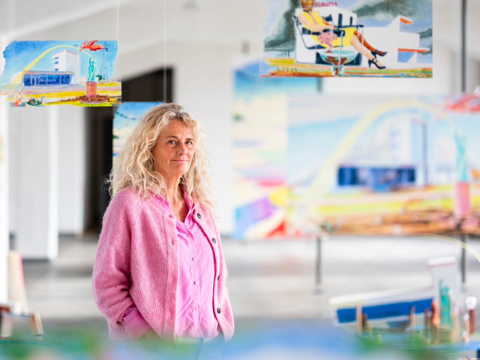 The artist Anna Meyer stands in front of her paintings in the Bauhaus building in Dessau.